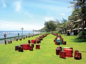 a row of tables on the grass near the beach at Homestay & Camping Phan Thiet Beach in Ấp Bình Hưng