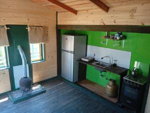 eine Küche mit einem Herd, einer Spüle und einem Kühlschrank in der Unterkunft La viuda del diablo cabañas in Punta Del Diablo