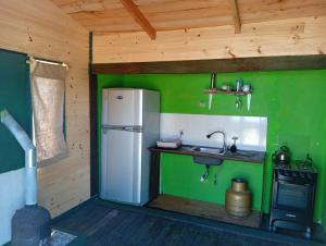 eine Küche mit einem weißen Kühlschrank und einer Spüle in der Unterkunft La viuda del diablo cabañas in Punta Del Diablo + 4 Fotos