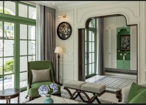 a living room with a green chair and windows at Green Villas Tropical Phú Quốc in Phu Quoc