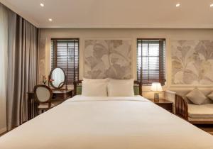 a bedroom with a large white bed and a chair at Green Villas Tropical Phú Quốc in Phu Quoc +190 photos
