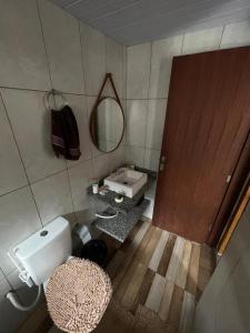 a bathroom with a toilet and a sink and a mirror at Riba Brisa in Imbituba +8 photos