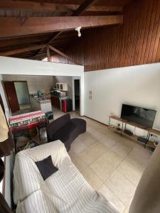 a living room with a couch and a tv at Riba Brisa in Imbituba