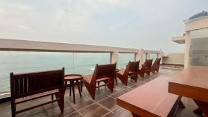 a balcony with chairs and tables and a view of the ocean at Eolie Loft in Colombo