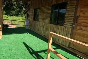 een veranda van een blokhut met een bank bij จรรยา โฮมเสตย์ in Chom Thong