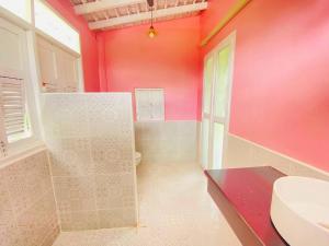 een badkamer met een toilet en een roze muur bij Today Sunset ที่พักวังน้ำเขียว in Ban Nong Chaeng +60 foto's
