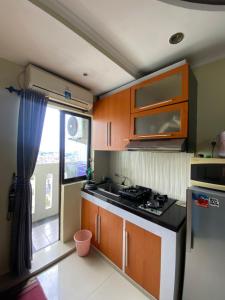 een keuken met een fornuis, een wastafel en een raam bij Gateway cicadas by aleshaproperty in Bandung