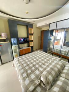 een slaapkamer met een bed met een geruite deken bij Gateway cicadas by aleshaproperty in Bandung