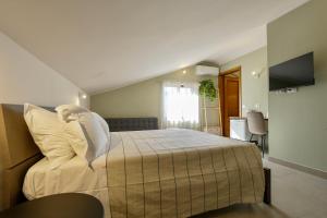 a bedroom with a bed with white pillows at Domus Fabia - Rooms & Apartments in San Gemini