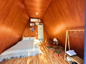 een slaapkamer met een bed en een houten wand bij Nà Bó Homestay in Mộc Châu +96 foto's