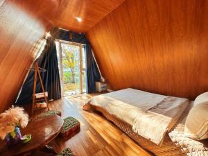 een slaapkamer met een bed en een houten wand bij Nà Bó Homestay in Mộc Châu