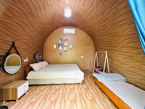 een slaapkamer met 2 bedden in een houten muur bij Nà Bó Homestay in Mộc Châu