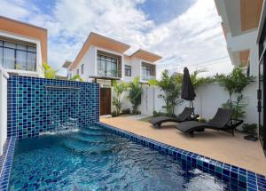 a swimming pool in front of a house at Goldena Residence Private Pool Villas in Kamala Beach