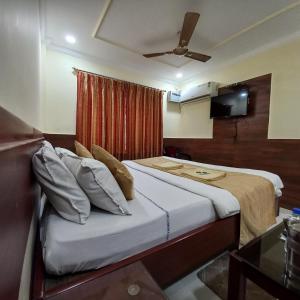 a bedroom with a large bed with a ceiling at Hotel Tazzodisha Next in Bhubaneshwar