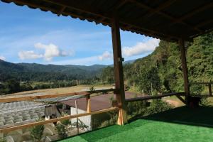 een uitzicht vanaf het balkon van een huis met bergen op de achtergrond bij จรรยา โฮมเสตย์ in Chom Thong