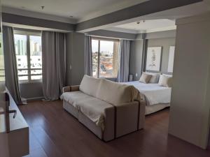 ein Schlafzimmer mit einem Bett und einer Couch und Fenstern in der Unterkunft GRU Airport Easy Stay in Guarulhos + 48 Fotos
