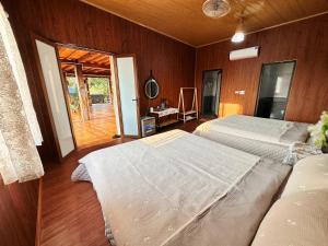 twee bedden in een slaapkamer met houten wanden en houten vloeren bij Nà Bó Homestay in Mộc Châu