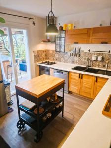 une cuisine avec une table en bois au milieu dans l'établissement Maison TIKI TAHITI, à Alès