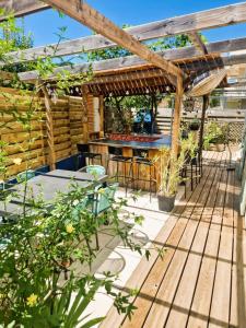 une terrasse avec un bar et une pergola en bois dans l'établissement Maison TIKI TAHITI, à Alès 17 autres photos