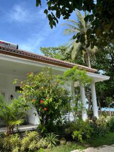 una casa con colonne bianche e fiori nel cortile di Damar Tree Resort a Krui