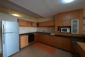 a kitchen with wooden cabinets and a white refrigerator at Chalets in Arez - Adagio in Al Arz +46 photos