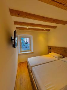 twee bedden in een kamer met een raam bij Casa Patty Moena in Moena