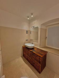 een badkamer met een witte wastafel en een houten wastafel bij Casa Patty Moena in Moena