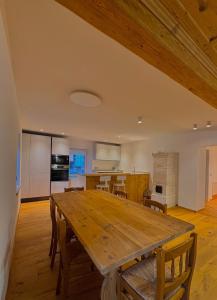 een grote houten tafel in een kamer met een keuken bij Casa Patty Moena in Moena