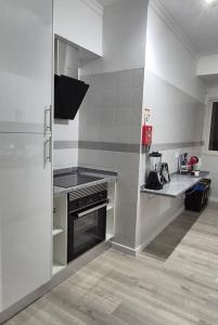 een keuken met een fornuis en een aanrechtblad bij O Lar da Elisa in Bicas