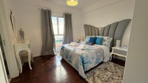 een slaapkamer met een bed met blauwe kussens en een raam bij O Lar da Elisa in Bicas