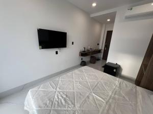 ein Schlafzimmer mit einem Bett mit einem Flachbildfernseher an der Wand in der Unterkunft H99 Homestay 