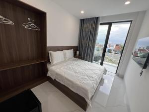 ein Schlafzimmer mit einem Bett und einem großen Fenster in der Unterkunft H99 Homestay 