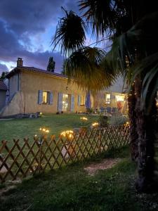 ein Haus mit einem Zaun vor einem Hof in der Unterkunft La Bastide in Armous-et-Cau