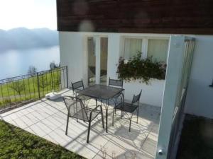 a patio with a table and chairs on a balcony at Apartment Oberwilen by Interhome in Vitznau +9 photos