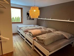 a room with four beds with pillows on them at Apartment Chasa Ernst by Interhome in Zernez +28 photos