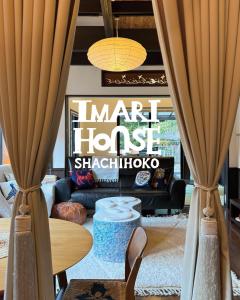 een woonkamer met een bank en een tafel bij IMARI HOUSE shachihoko イマリハウス しゃちほこ in Imari