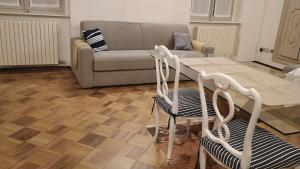 a living room with a couch and a table and chairs at FuoriPorta Affitti Brevi - L'Appartamento della Musica in Parma