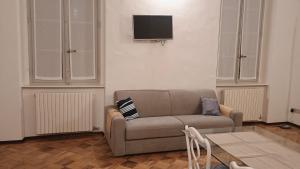 a living room with a couch and a tv on a wall at FuoriPorta Affitti Brevi - L'Appartamento della Musica in Parma