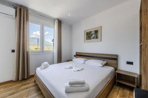 a bedroom with a bed with white towels on it at Bliss by PikHost in Gjirokastër
