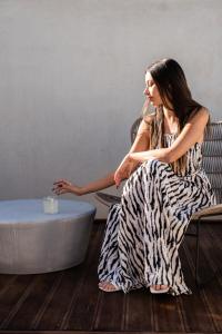 a woman sitting in a chair next to a tub at VAYA Suites by Omilos Hotels in Amoudara Herakliou