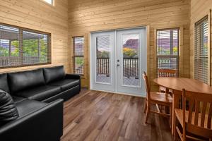 un soggiorno con un divano nero e un tavolo di Sun Outdoors North Moab a Moab