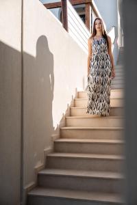 a woman is walking down the stairs at VAYA Suites by Omilos Hotels in Amoudara Herakliou