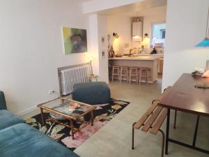a living room with a blue couch and a table at Le grenier à sel, maison de pécheur pour 6 avec salle TV in Fécamp