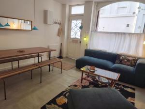 a living room with a blue couch and a table at Le grenier à sel, maison de pécheur pour 6 avec salle TV in Fécamp