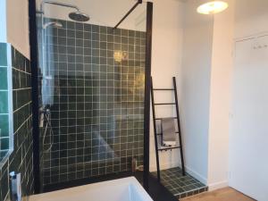 a bathroom with a shower with a tub at Le grenier à sel, maison de pécheur pour 6 avec salle TV in Fécamp +42 photos