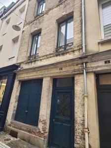 a brick building with a blue door and windows at Le grenier à sel, maison de pécheur pour 6 avec salle TV in Fécamp