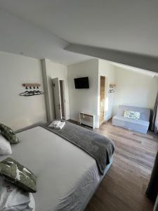 een slaapkamer met een groot bed en een bank bij Junqueira76 Guesthouse in Póvoa de Varzim