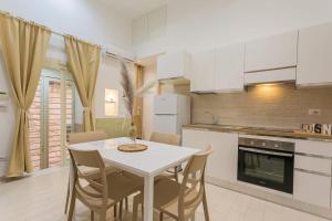 a kitchen with a white table and chairs in it at Il borgo incantato in Bitonto