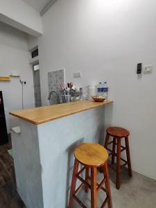 een keuken met 2 krukken en een aanrecht bij Sunny Nest in Gopeng