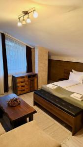a bedroom with a large bed and a table at Deluxe 707 in Borovets